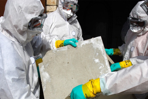People in hazmat suits, removing asbestos from a building.